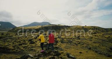 在冰岛熔岩上<strong>行走的</strong>游客<strong>的</strong>鸟瞰图。 两个女人在山上徒步旅行，享受这个爱好。
